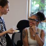 Care Coordinator and Support Worker share a friendly conversation during a relaxed break indoors.